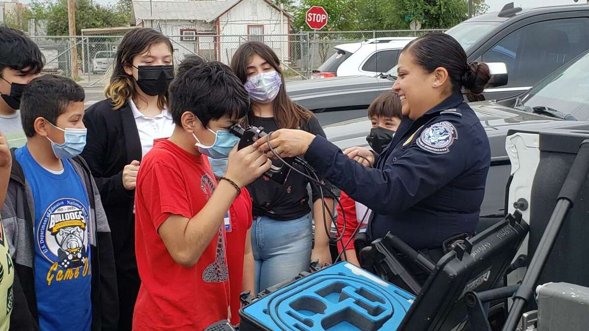 A U.S. Customs and Border Protection officer demonstrates J.C. Martin Elementary fifth graders how to use a camera to inspect gas tanks.