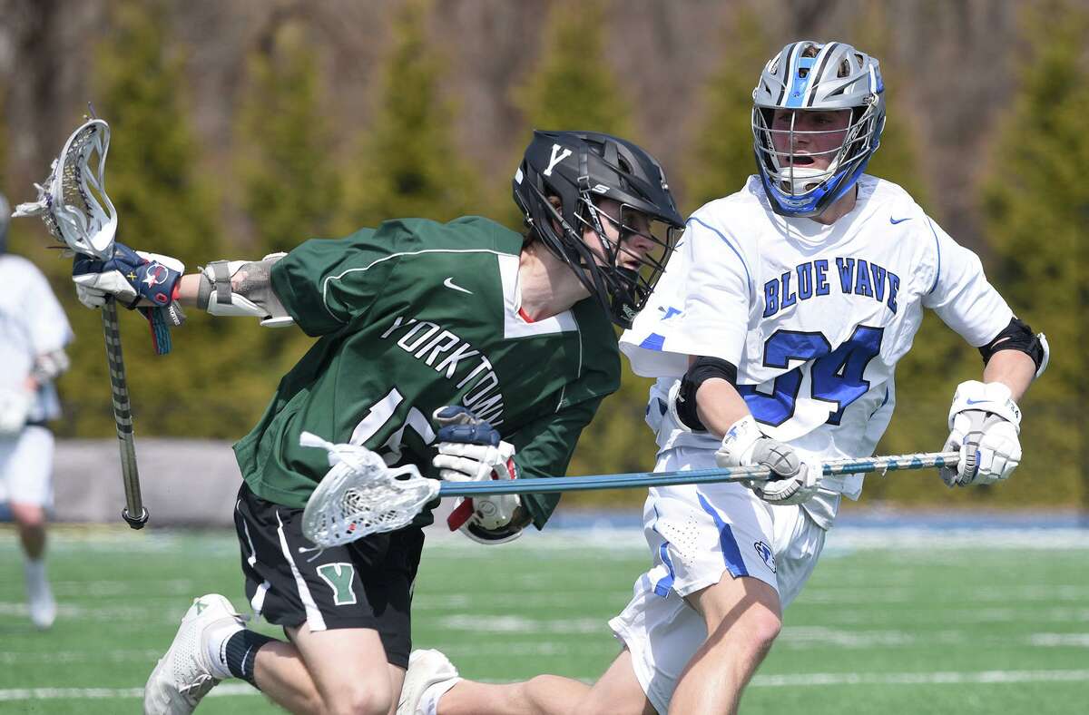 Darien’s Tyler Strub (34) defends against Yorktown’s Tim O’Callaghan during the Wave’s 11-7 win at Darien High School on March 30.