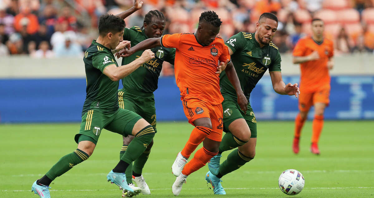 Houston Dynamo FC forward Carlos Darwin Quintero (23) tries to maintain control of the ball against Portland Timbers defenders during the first half of an MLS match at PNC Stadium on Saturday, April 16, 2022, in Houston.