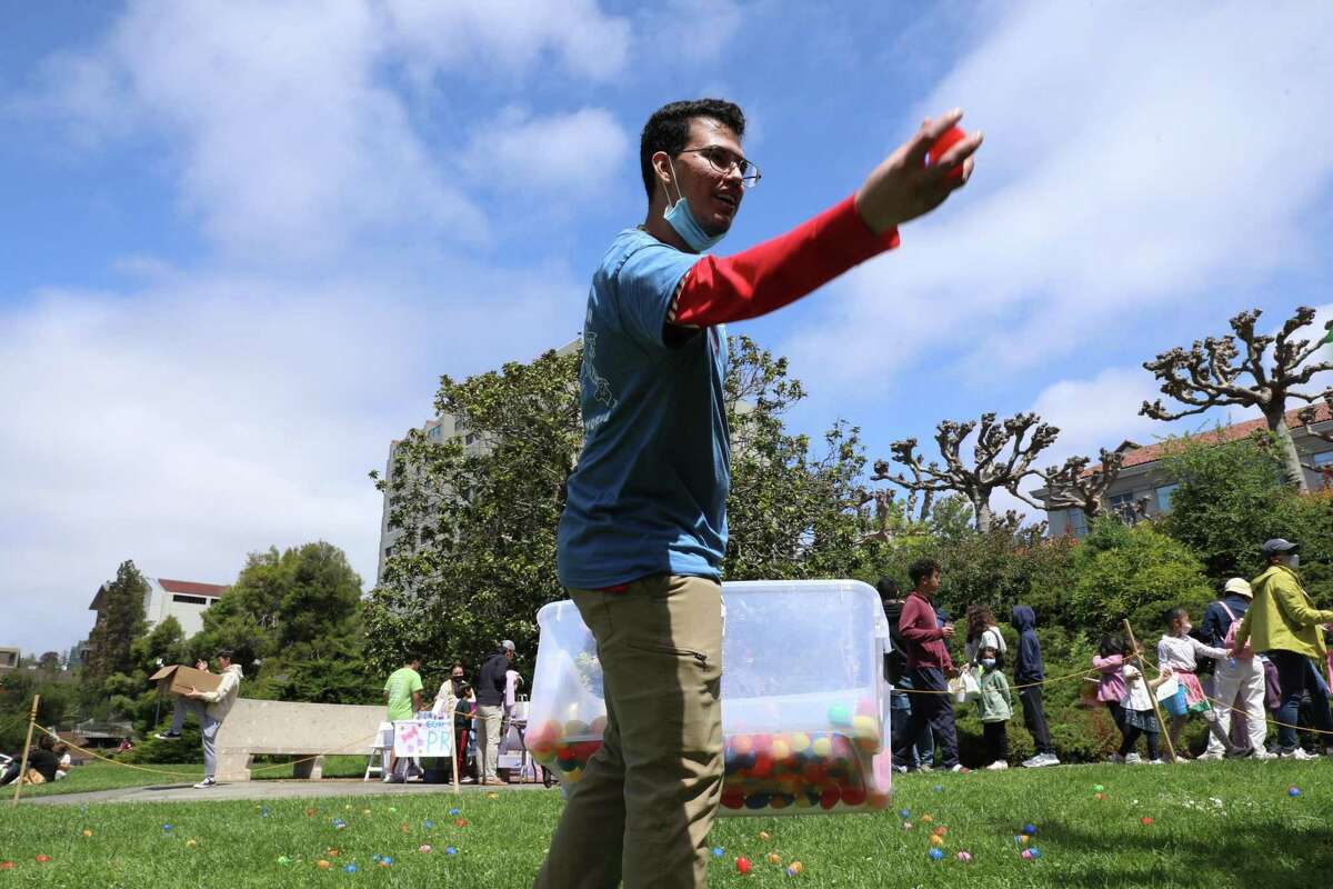 Freshman molecular cell biology major Michael Rodriguez, 18, of Los Angeles, distributes Easter eggs following a morning rain delay during the 28th annual Eggster event at UC Berkeley on Saturday, April 16, 2022, in Berkeley, Calif.  