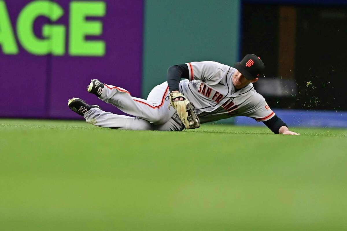 San Francisco Giants right fielder Mike Yastrzemski slides after catching a ball hit by Cleveland Guardians' Josh Naylor in the fourth inning of a baseball game, Saturday, April 16, 2022, in Cleveland. (AP Photo/David Dermer)