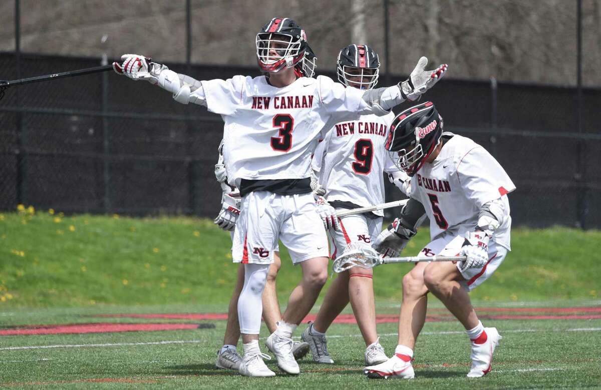 New Canaan's Carter Connors (3), Michael Norton (5) and Ryan Connelly (9) celebrate a goal against Darien during a boys lacrosse game in New Canaan on Saturday, April 16, 2022.