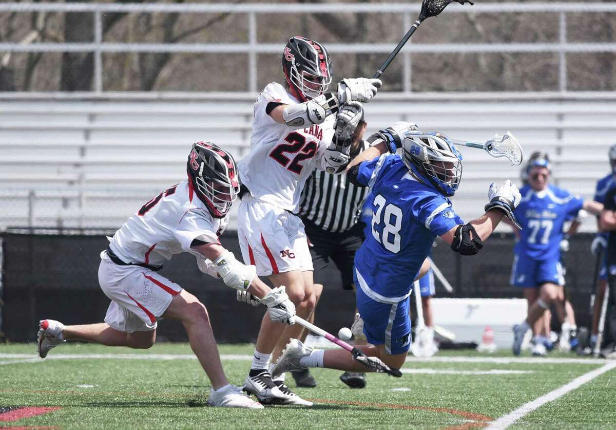 New Canaan's John Totaro (15) and Walker Blair (22) battle Darien's Tighe Cummiskey (28) during a boys lacrosse game in New Canaan on Saturday, April 16, 2022.