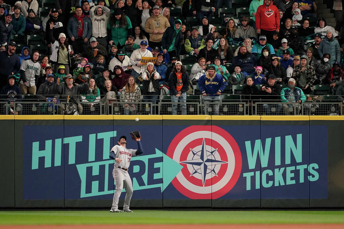 Fans react as Houston Astros right fielder Kyle Tucker catches a fly ball hit by Seattle Mariners' Cal Raleigh for an out during the sixth inning of a baseball game, Saturday, April 16, 2022, in Seattle. (AP Photo/Ted S. Warren)