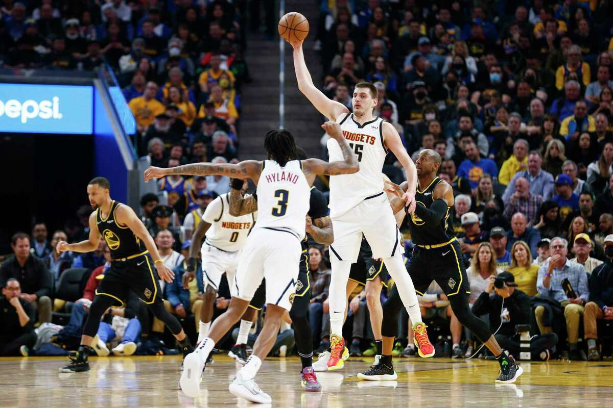 Denver Nuggets center Nikola Jokic (15) grabs the high pass while guarded by Golden State Warriors forward Andre Iguodala (9) in the first half during Game 1 of the NBA first-round playoff series at Chase Center, Saturday, April 16, 2022, in San Francisco, Calif.
