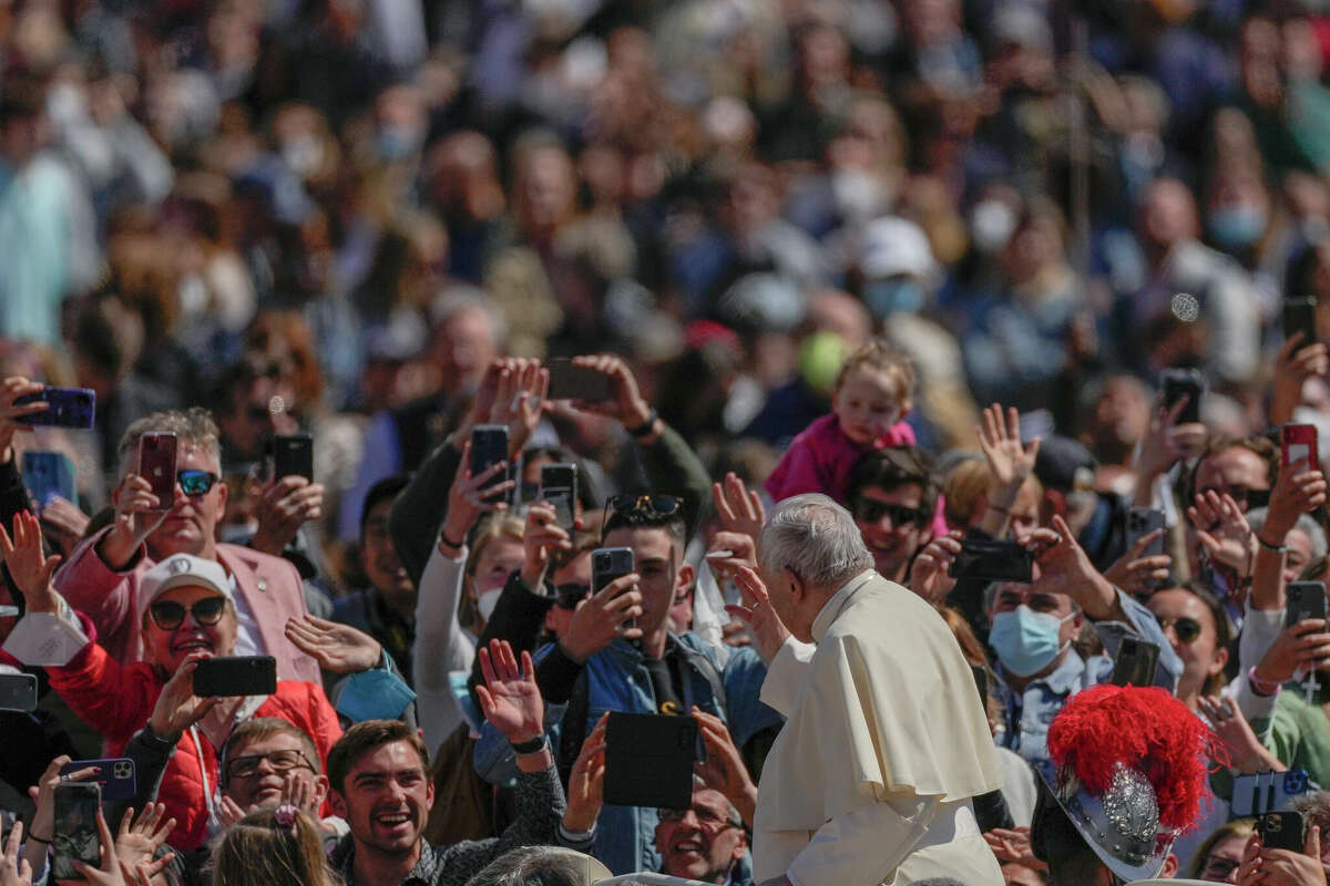 Pope Francis on his popemobile moves through a crowd at the end of the Catholic Easter Sunday mass he led in St. Peter's Square at the Vatican, Sunday, April 17, 2022. For many Christians, this marked the first time in three years they gathered in person to celebrate Easter Sunday.