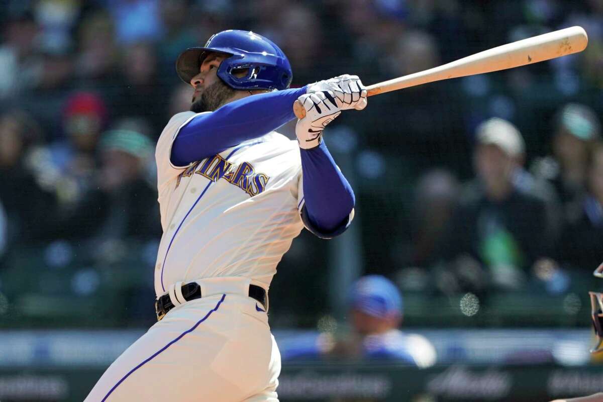 Seattle Mariners' Eugenio Suarez follows through on an RBI double to score Ty France during the first inning of a baseball game against the Houston Astros, Sunday, April 17, 2022, in Seattle. (AP Photo/Ted S. Warren)