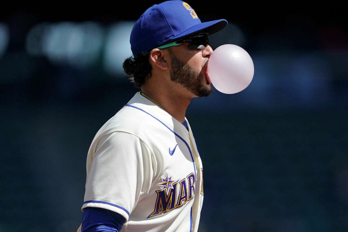 Seattle Mariners third baseman Eugenio Suarez blows a bubble with his gum during the first inning of a baseball game against the Houston Astros, Sunday, April 17, 2022, in Seattle. (AP Photo/Ted S. Warren)