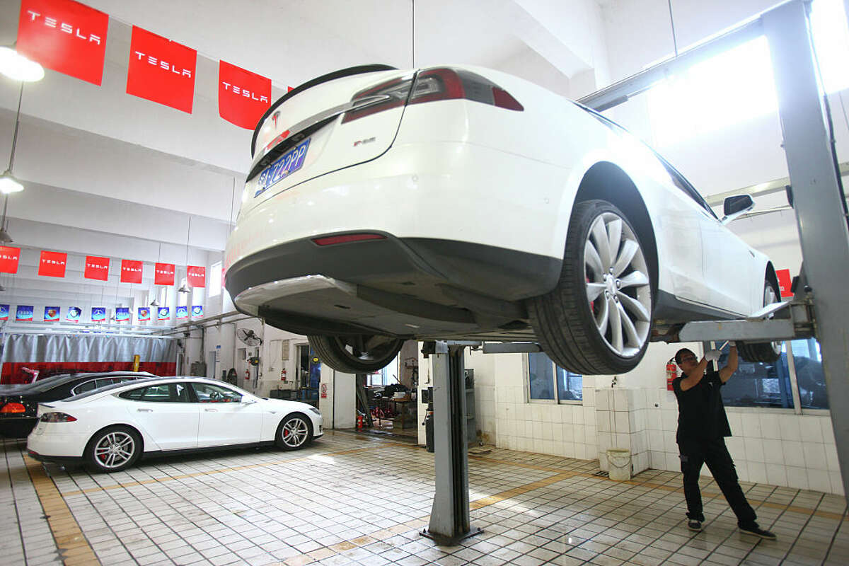 NINGBO, CHINA - JUNE 11: (CHINA OUT) A maintenance technician examines and repairs a Tesla vehicle by connecting it with computer on June 11, 2015 in Ningbo, Zhejiang province of China. Tesla Motors set authorized service centers in many cities in China to provide most convenient service for customers near these centers. (Photo by Visual China Group via Getty Images/Visual China Group via Getty Images)
