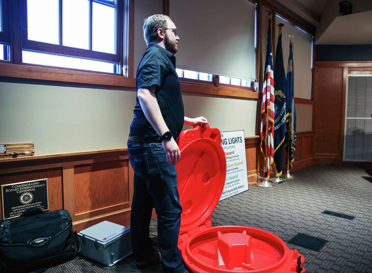 Jacob Soter opens up an orange container which normally holds a "Life Ring" system which could be tossed out to someone who has trouble swimming and could be pulled back to shore before drowning. Soter noted the system could be used for either the Manistee River or Lake Michigan 
