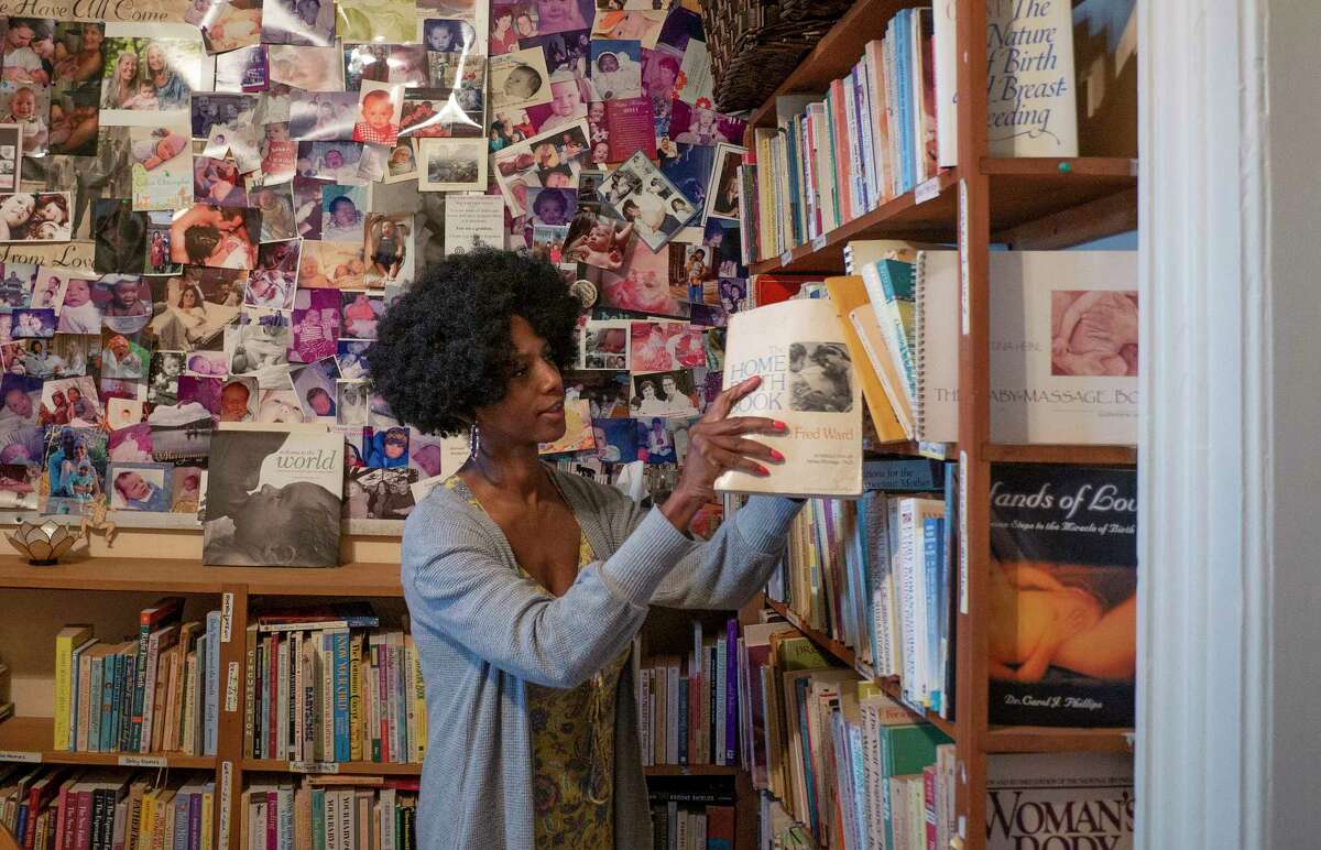 Nakia Tillman, a co-chair of BirthNet, looks through books on a shelf at Family Life Center on Monday, April 18, 2022, in Albany, N.Y. (Paul Buckowski/Times Union)