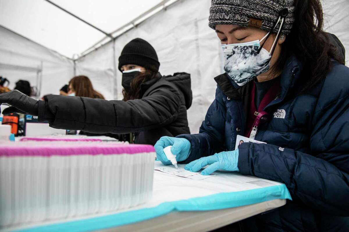Phlebotomist Khaliun Gombojav prepares a BinaxNow COVID-19 test card at a community testing site managed by Unidos en Salud in the Mission District of San Francisco, California Friday, Jan. 7, 2022.
