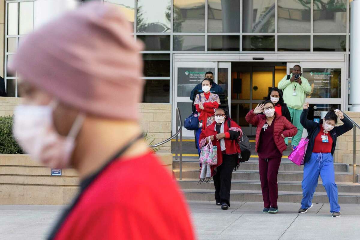 Jacquelyn Chen (right) dances while leaving work to join fellow nurses with California Nurses Association on a one-day strike at Alta Bates Summit campus in Oakland.