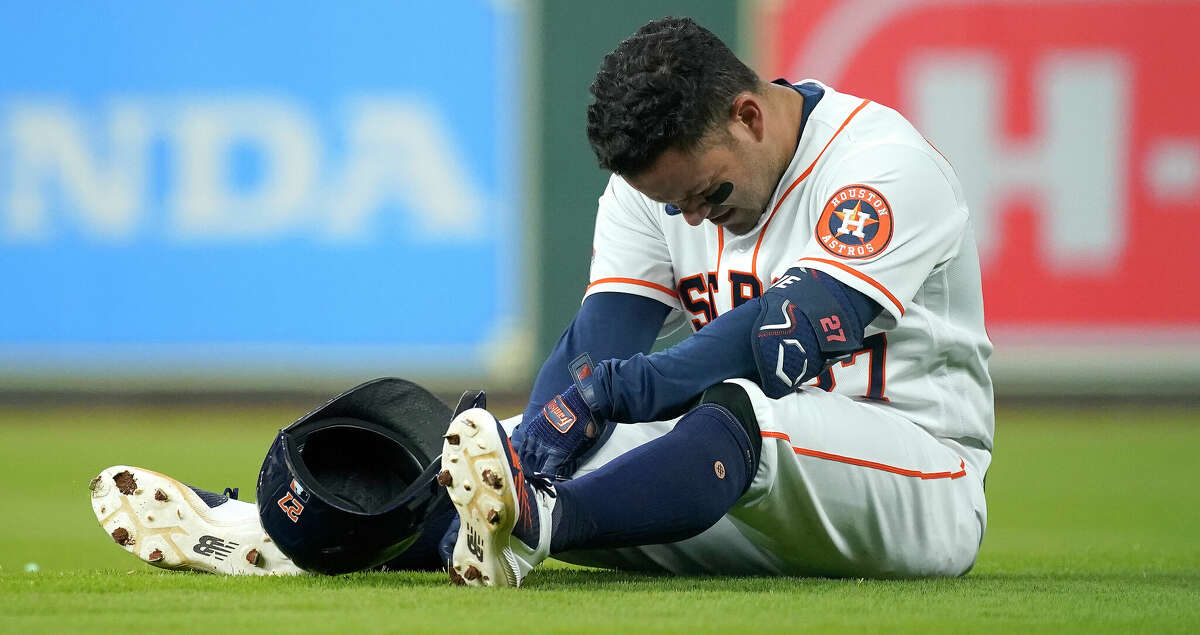 Houston Astros Jose Altuve (27) on the ground after being injured after hitting a single during the eighth inning of the Astros home opener MLB baseball game at Minute Maid Park on Monday, April 18, 2022 in Houston.