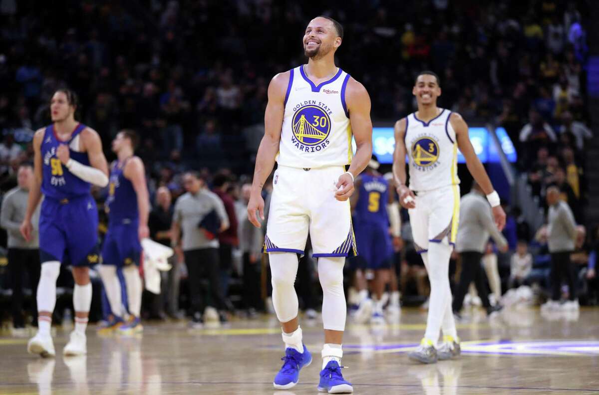 Golden State Warriors’ Stephen Curry and Jordan Poole smile in 2nd quarter against Denver Nuggets in Game 2 of NBA Western Conference 1st round playoff series at Chase Center in San Francisco, Calif, on Monday, April 18, 2022.