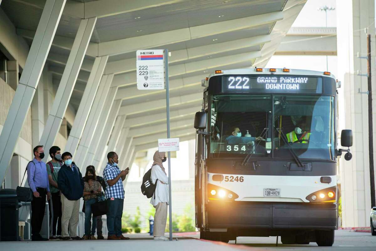 Masked commuters line up to board a Metropolitan Transit Authority bus to downtown at the Grand Parkway park and ride, Thursday, April 14, 2022, in Katy. After a federal judge struck down the mask mandate on buses and trains on Monday, Metro said it was not enforcing, but encouraging, mask use.