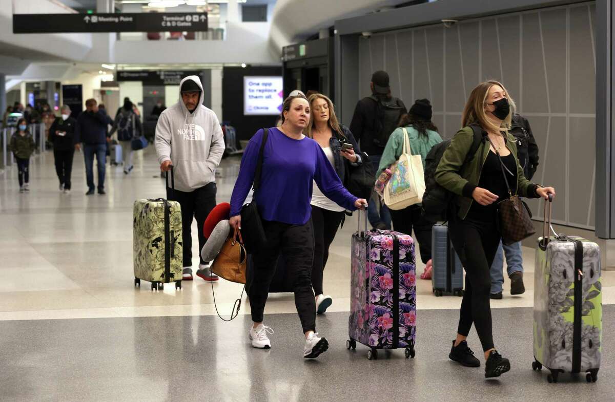 SAN FRANCISCO, CALIFORNIA - APRIL 19: Airline passengers without face masks walk through San Francisco International Airport on April 19, 2022 in San Francisco, California. The Transportation Security Administration (TSA) will not enforce a federal Covid-19 mask mandate on airplanes or public transportation after a federal judge in Florida struck down the mandate that applied to airports, airplanes and public transportation, ruling that the Centers for Disease Control and Prevention (CDC) had overstepped its authority. The CDC still recommends wearing masks on public transit. (Photo by Justin Sullivan/Getty Images)