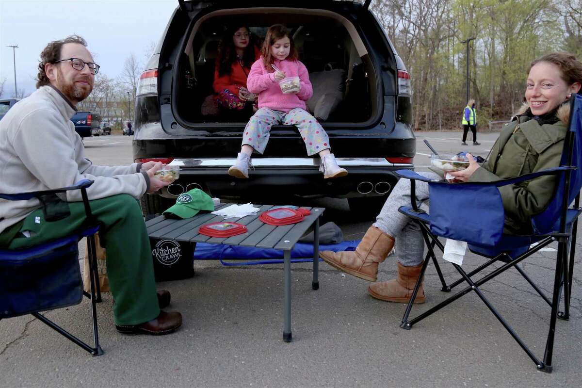 The Dombrow family of Westport, including from left Matt, Leah, 11, Alexa, 8, and Melissa, enjoy a tailgate at the Remarkable Theater's drive-in showing of “Goonies” on Friday, April 16, 2021, in Westport, Conn.