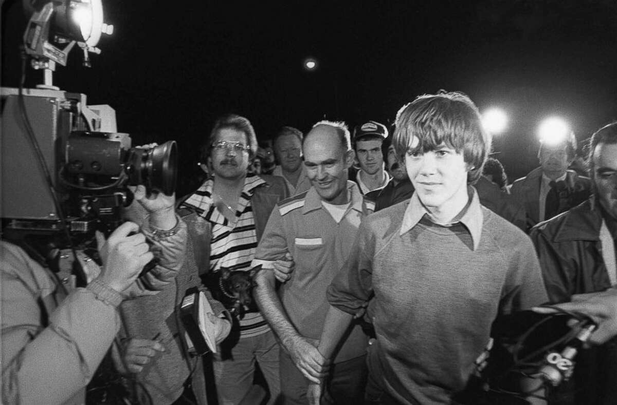 Surrounded by TV cameras, Steven Stayner, right foreground, and father Delbert Stayner are shown walking toward their Merced County, Calif., home in this March 2, 1980, file photo, after Steven was reunited with his family following a 7-year kidnap ordeal. A third brother, Cary Stayner, is seen in a ball cap in the background.