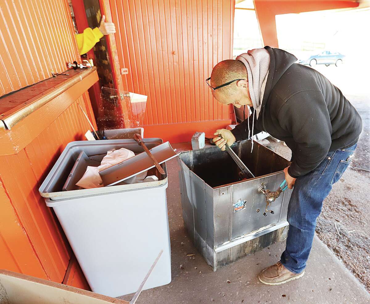 Fred Shaw works on an old root beer dispenser Tuesday outside Charlie's Drive-In, 762 N. Wood River Avenue, as the business continues to prepare to open in early May, possibly May 4. There was still a lot of work to be done Tuesday but the new owner, Chastity Niemeyer, is planning to open with the same menu items and service.