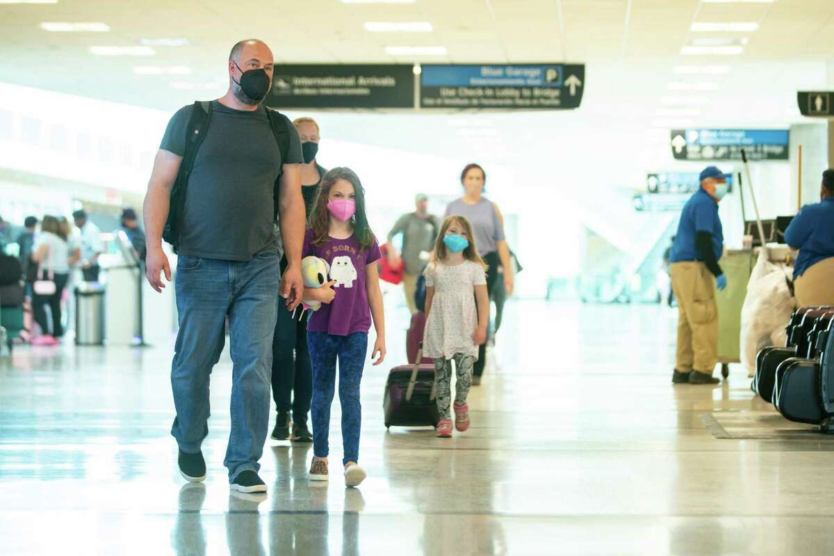Brian Zink walks with his daughter, Charlotte, 8, and wife Karen, with their daughter, Ceci, 5, on their way to the security line while traveling back to their home in Baltimore through Hobby Airport, Tuesday, April 19, 2022, in Houston. On Monday evening, a Federal judge in Florida struck down a national mask mandate on airplane and other forms of mass transit, meaning travelers are no longer required to wear face coverings.