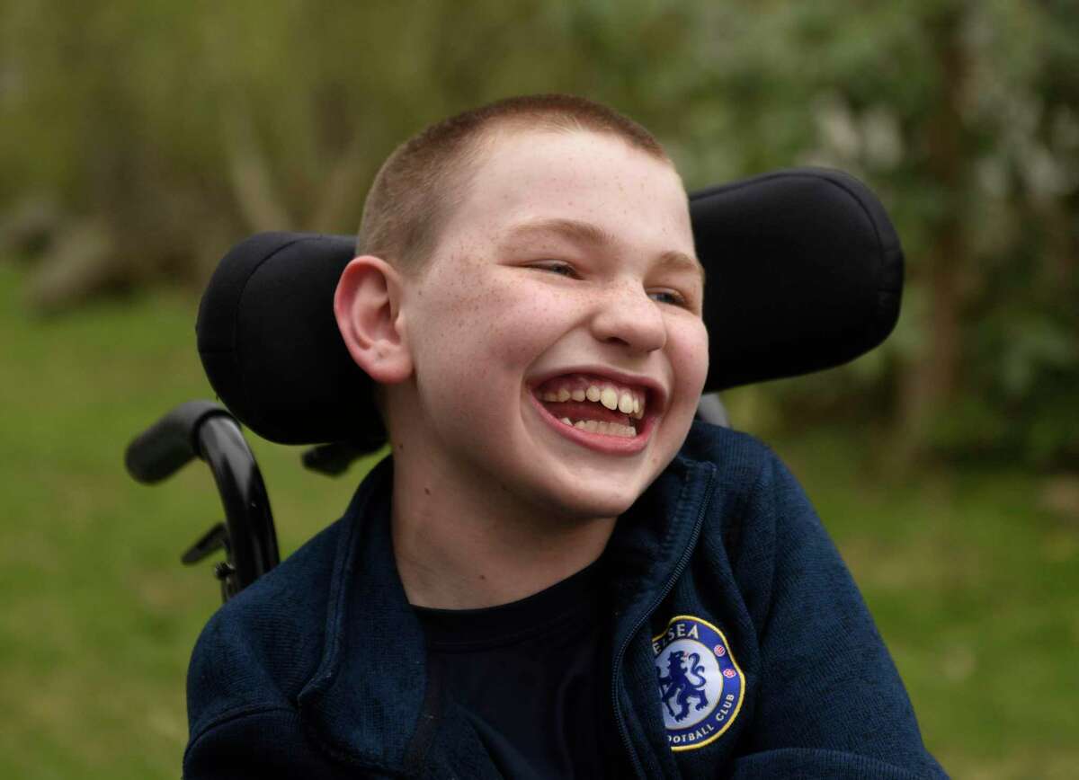 Sam Buck, 11, who has Vanishing White Matter Disease, smiles at his home in Greenwich, Conn. Monday, April 18, 2022. April 28 is "Mismatched Day," where Greenwich Public Schools students are encouraged to wear mismatched socks and shoes and donate $10 to the Vanishing White Matter Foundation in support of Sam Buck, who has the rare disease.