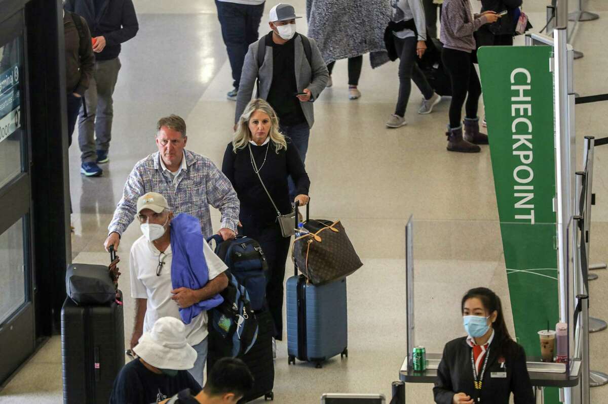 Travelers make their way toward security at Terminal 3 at San Francisco International Airport in San Francisco, Calif. on Tuesday, April 19, 2022. Following a Florida judge’s decision to strike down mask mandates, three major Bay Area airports will not require travelers to wear masks.