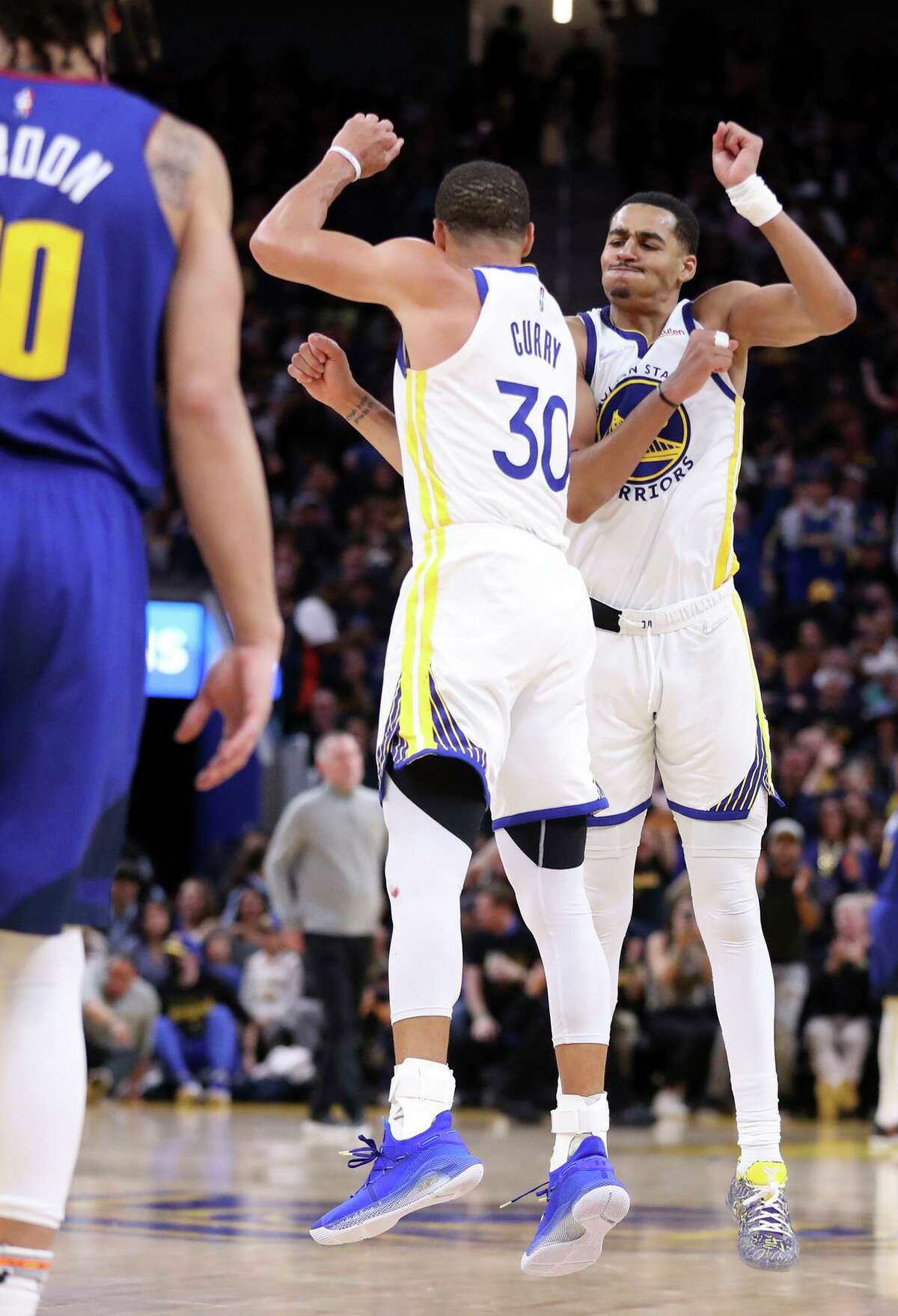 Warriors guards Jordan Poole and Stephen Curry celebrate Curry’s basket in the fourth quarter of a 126-106 win over the Denver Nuggets in Game 2 of their first-round series.