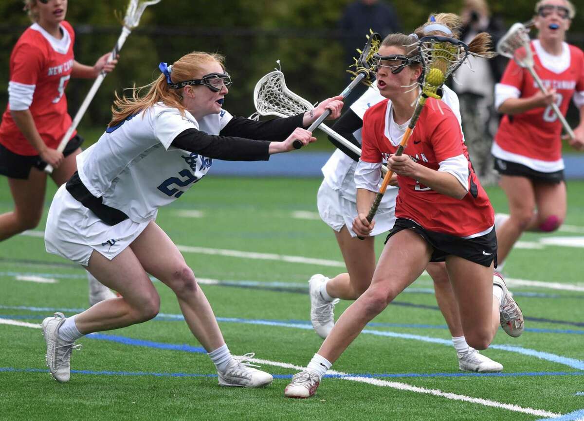 Darien's Kate Demark (23) defends against New Canaan's Dillyn Patten (3) during a girls lacrosse game in Darien on Tuesday.