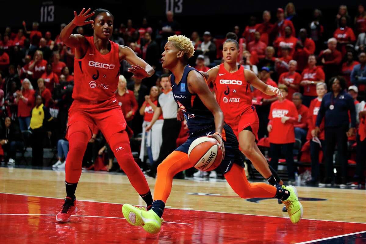 Connecticut Sun guard Courtney Williams, center, drives between Washington Mystics forward LaToya Sanders, left, and guard Natasha Cloud during the first half of Game 5 of the WNBA Finals in 2019.
