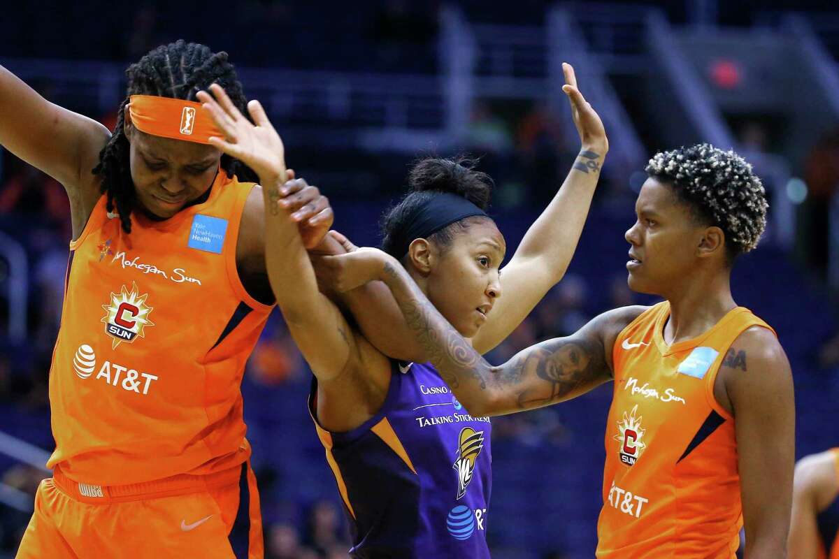Connecticut Sun guard Courtney Williams, right, pulls apart Sun forward Jonquel Jones, left, and Phoenix Mercury guard Briann January, middle, during the second half of a WNBA basketball game Wednesday, Aug. 14, 2019, in Phoenix. (AP Photo/Ross D. Franklin)
