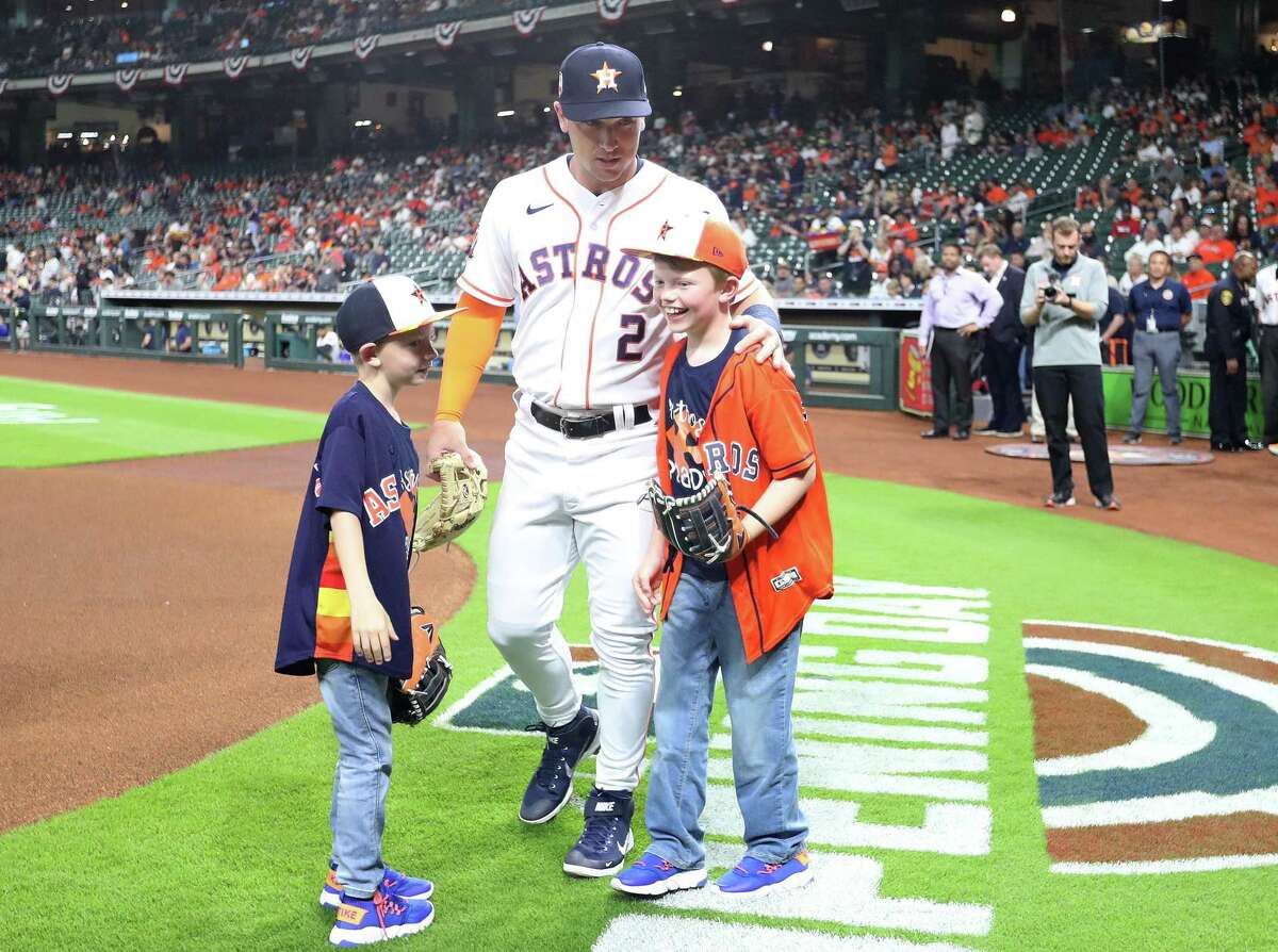Astros third baseman Alex Bregman accompanies Brady Columbus, right, and his brother Bryant before Brady threw out the first pitch at Minute Maid Park on Tuesday night.