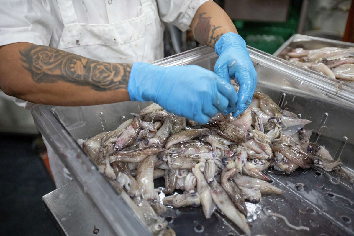 A cook prepares some seafood at the Peruvian restaurant La Costenera in Half Moon Bay Calif. on April 12, 2022.