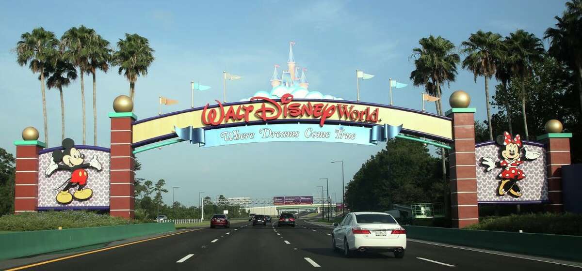 FILE: Visitors drive past a sign welcoming them to Walt Disney World on the first day of reopening of the iconic Magic Kingdom theme park in Orlando, Florida, on July 11, 2020.
