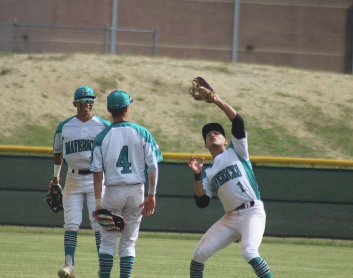 With teammates looking on, Memorial's Diego Saenz battles the wind Tuesday in corralling this fly ball Tuesday.