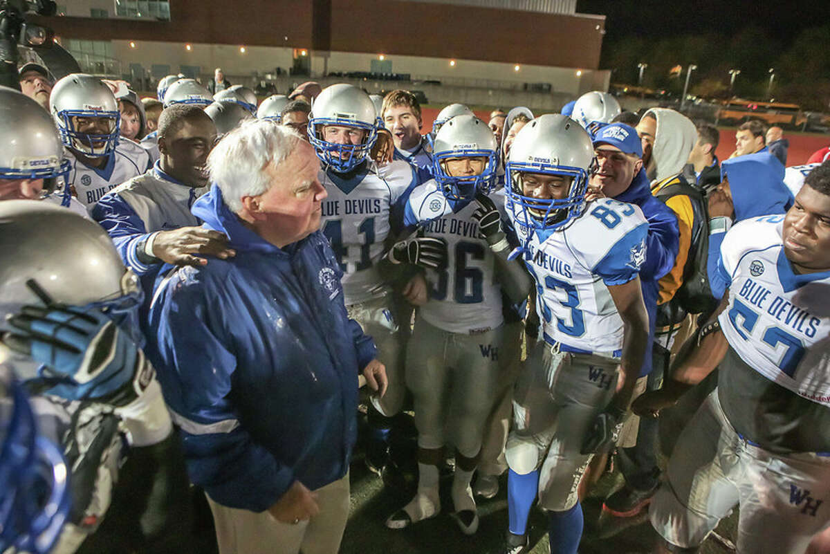 West Haven football coach Ed McCarthy is congratulated by his players on his 322 career win. McCarthy’s Blue Devils defeated Hamden 49-7 to achieve the milestone victory. John Vanacore – for the Register