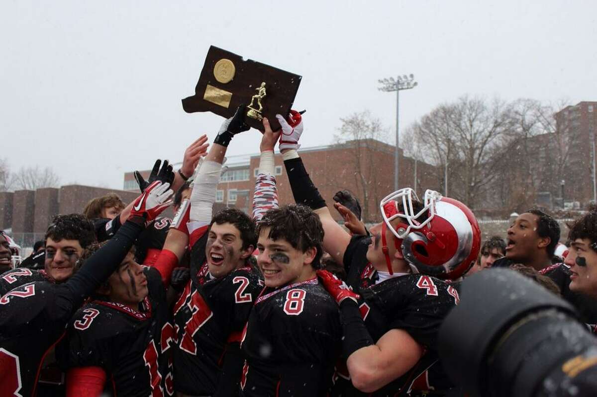 New Canaan’s football players hold the state championship trophy after defeating Darien 44-12 in the Class L title game (via Terry Dinan via Twitter)