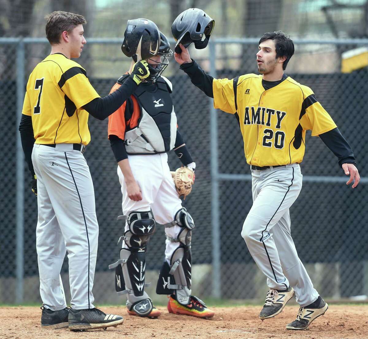 John Lumpinski (left) of Amity congratulates Jared Smith after his first of two home runs against Shelton in Woodbridge on April 30, 2018.
