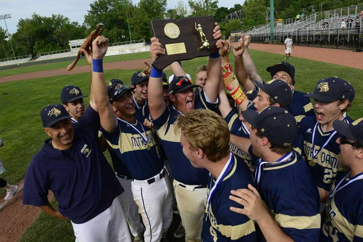 Notre Dame-Fairfield Pete Minore (28) holds up the winning plaque as players celebrate their10-6 win over Coventry in the CIAC Class S baseball finals at Palmer Field Stadium on June 9, 2018 in Middletown, Connecticut.