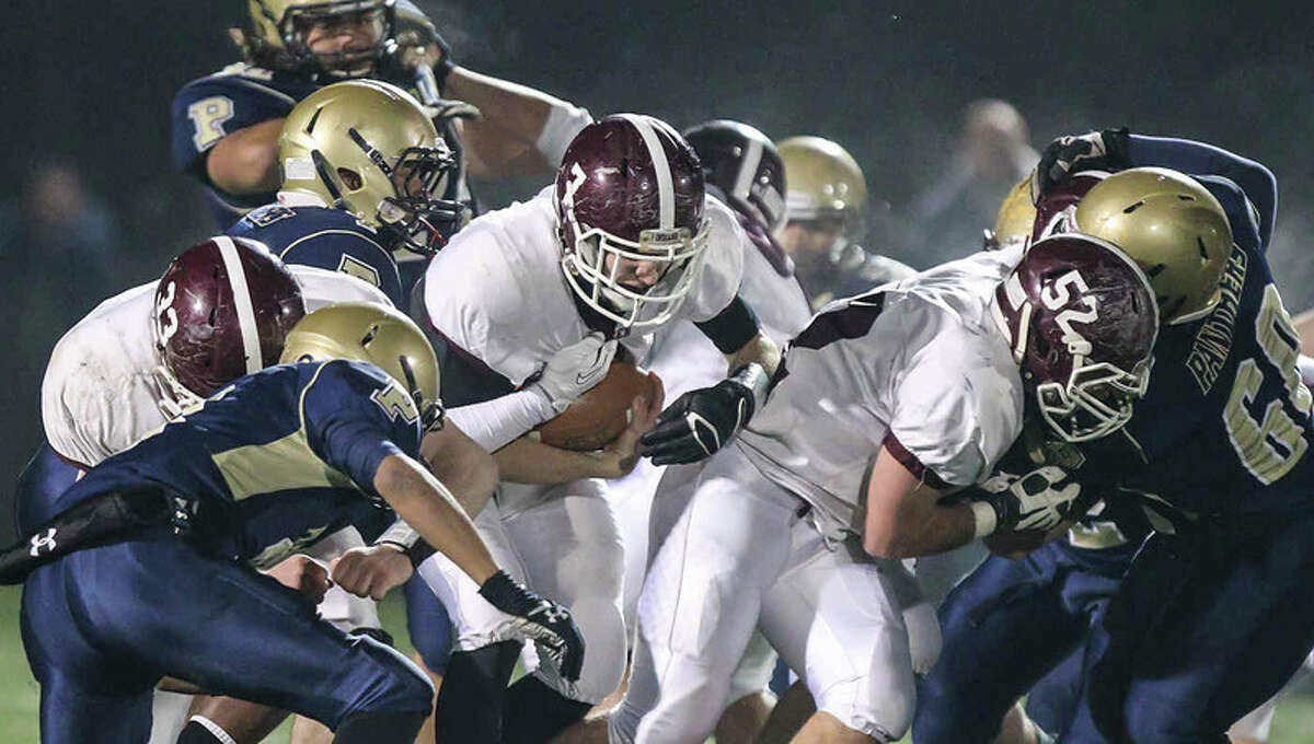 North Haven running back Mike Halloran gets blocks from Ethan Sauraci(33) and Austion Mahon(52) during North Haven’s quarterfinal victory over Platt-Meriden. The CIAC voted to eliminate the quarterfinal round for 2014, but keep the 32 playoff qualifiers, giving the state potentially eight playoff classes. (John Vanacore for the Register)