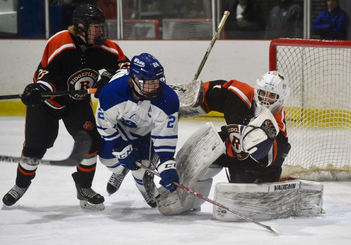 Ridgefield goalie Sean Gordon makes a save as Darien’s Hudson Pokorny (21) and Ridgefield’s Patrick Rigby battle in front during a boys hockey game at the Darien Ice House on Sat., Jan. 12. (Dave Stewart, Hearst Connecticut Media)