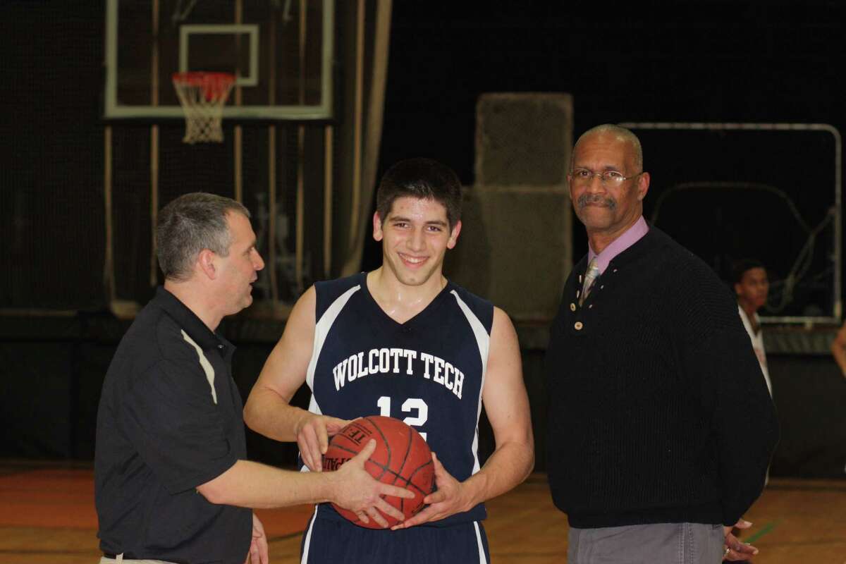 Wolcott Tech’s Luke Pergola, Center, is awarded the game ball by Wolcott Tech athletic director Ray Tanguay, left, and Wolcott Tech head coach Rene Williams.
