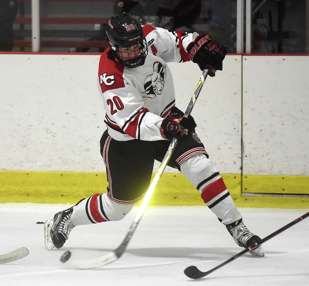 New Canaan defenseman Walker Ker takes a shot during a boys ice hockey game at the Darien Ice House on Monday, Feb. 4.