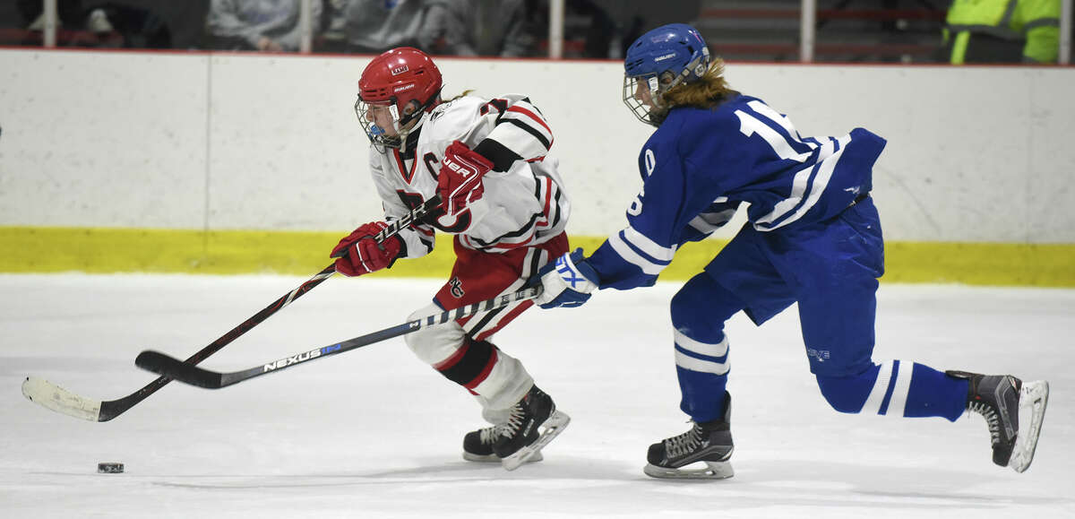 New Canaan senior co-captain Jess Eccleston (7) gets out in front of Darien’s Shea van den Broek during a rivalry game at the Darien Ice House on Jan. 26.