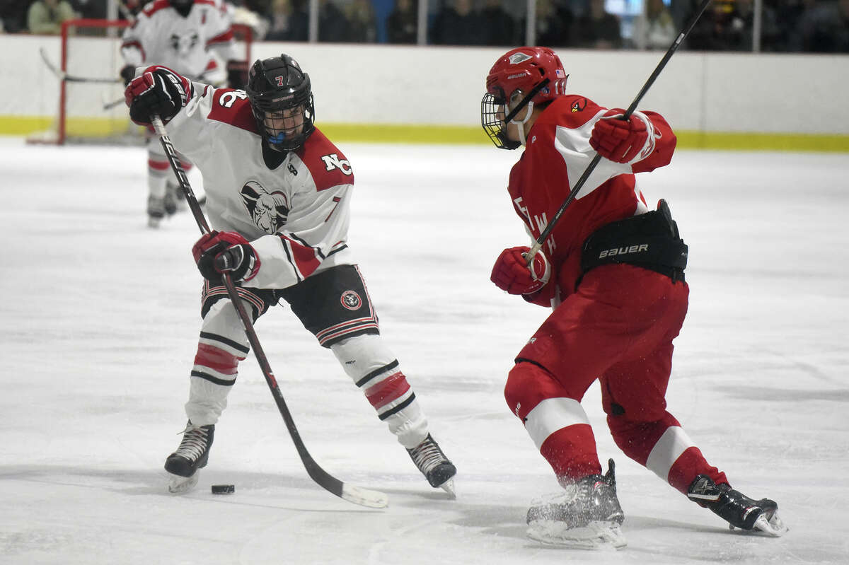 New Canaan’s Brendan Knightly (7) and Greenwich’s Dylan Madden (11) battle for the puck during the first round of the CIAC Div. I tournament on Tuesday, March 5, at the Darien Ice House.