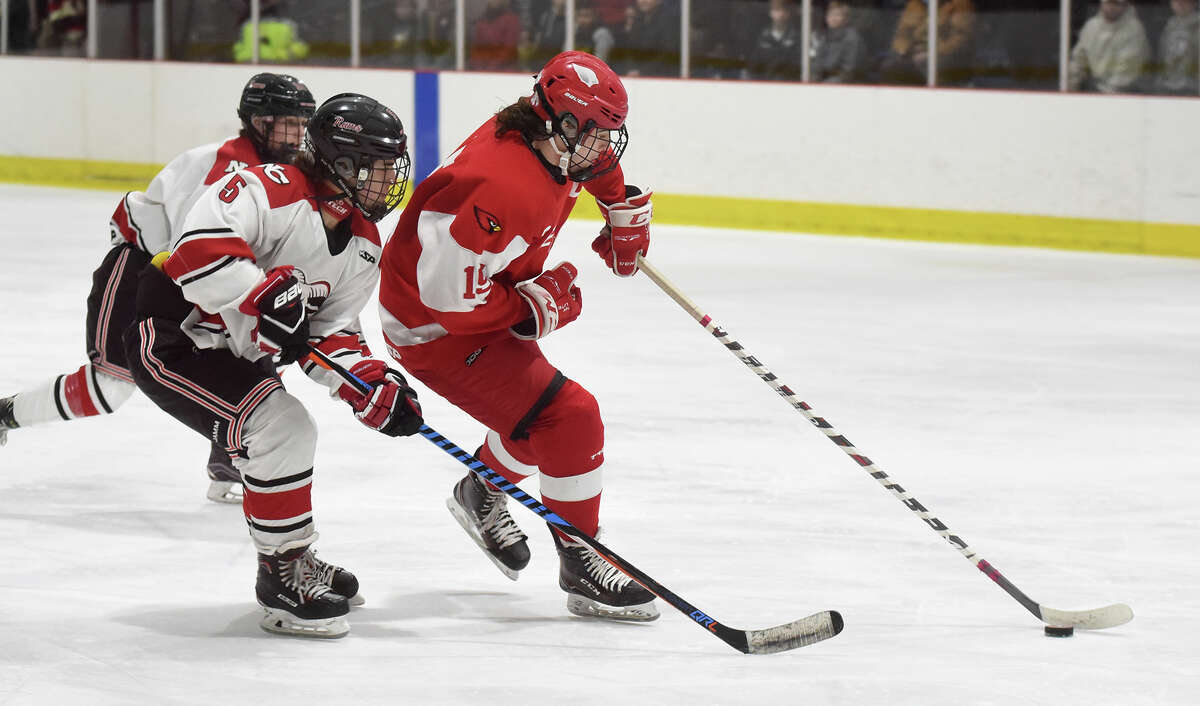 Greenwich's Matthew Davey (15) skates into the zone as New Canaan's Eric Wills (5) defends during Tuesday's Div. I tournament first round game at the Darien Ice House.