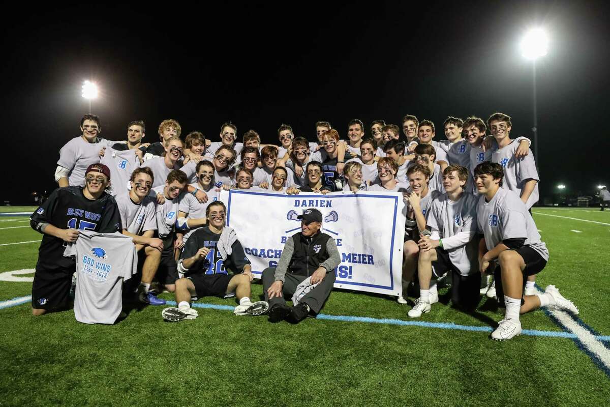 The Darien Boys Varsity Lacrosse team pose with Head Coach Jeff Brameier and a banner celebrating his 600th win just after during a game between Darien Boys Varsity Lacrosse and Wilton Boys Varsity Lacrosse on April 18, 2019 at Wilton High School in Wilton, CT.