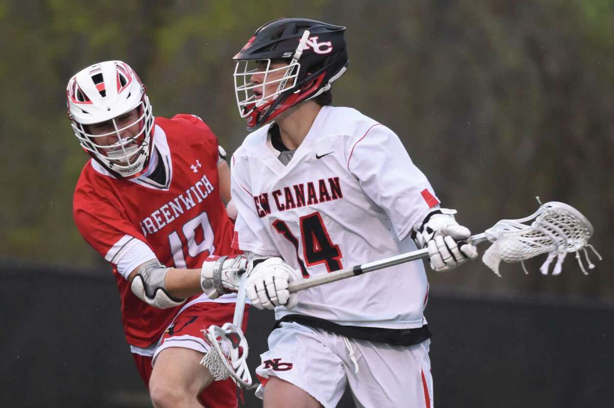 New Canaan’s Luke Nolan (14) with the ball while Greenwich’s Jason Tautel (19) defends during a boys lacrosse game at Dunning Field in New Canaan on Thursday, April 25, 2019.