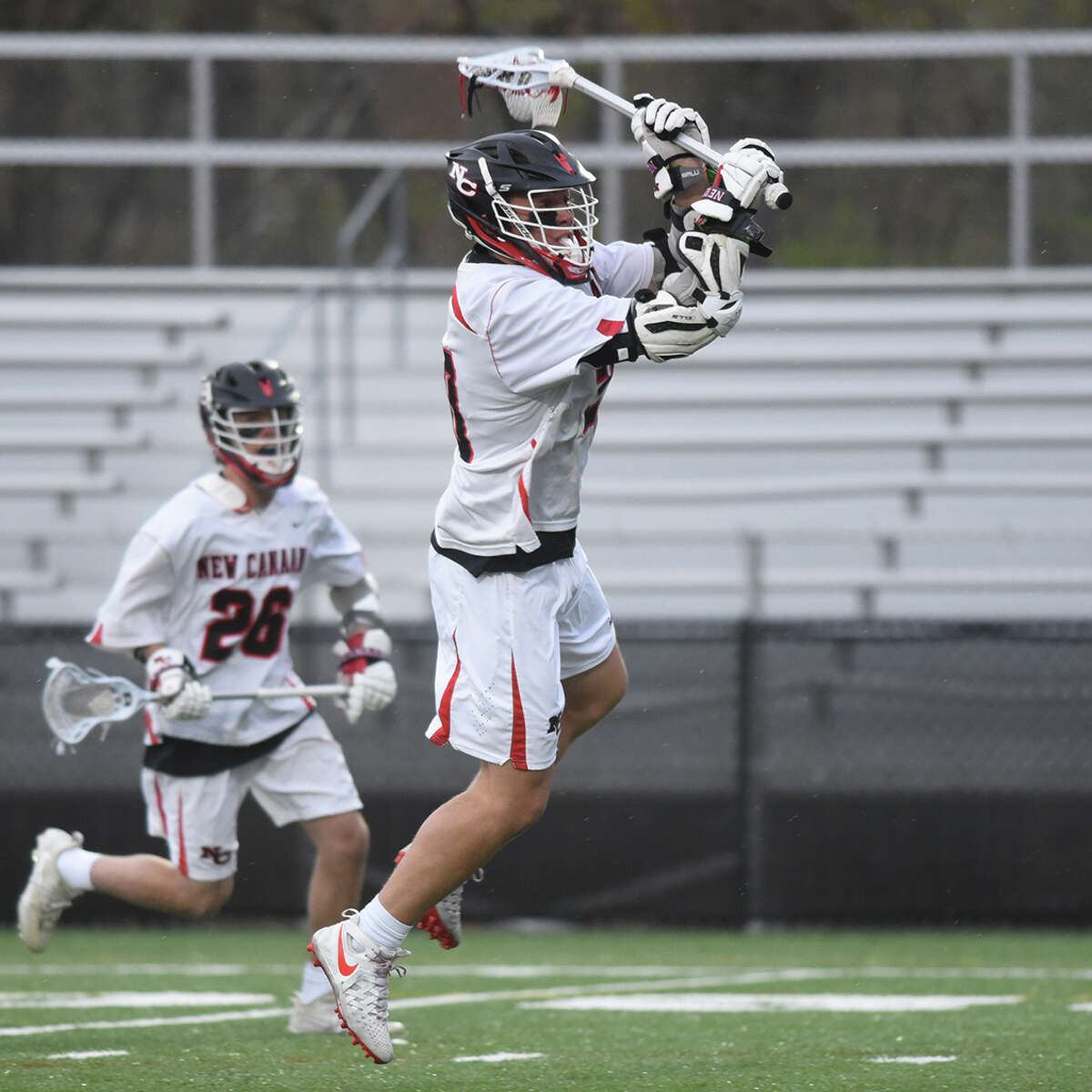 New Canaan’s Quintin O’Connell leaves his feet for a shot during a boys lacrosse game at Dunning Field in New Canaan on Thursday, April 25, 2019.