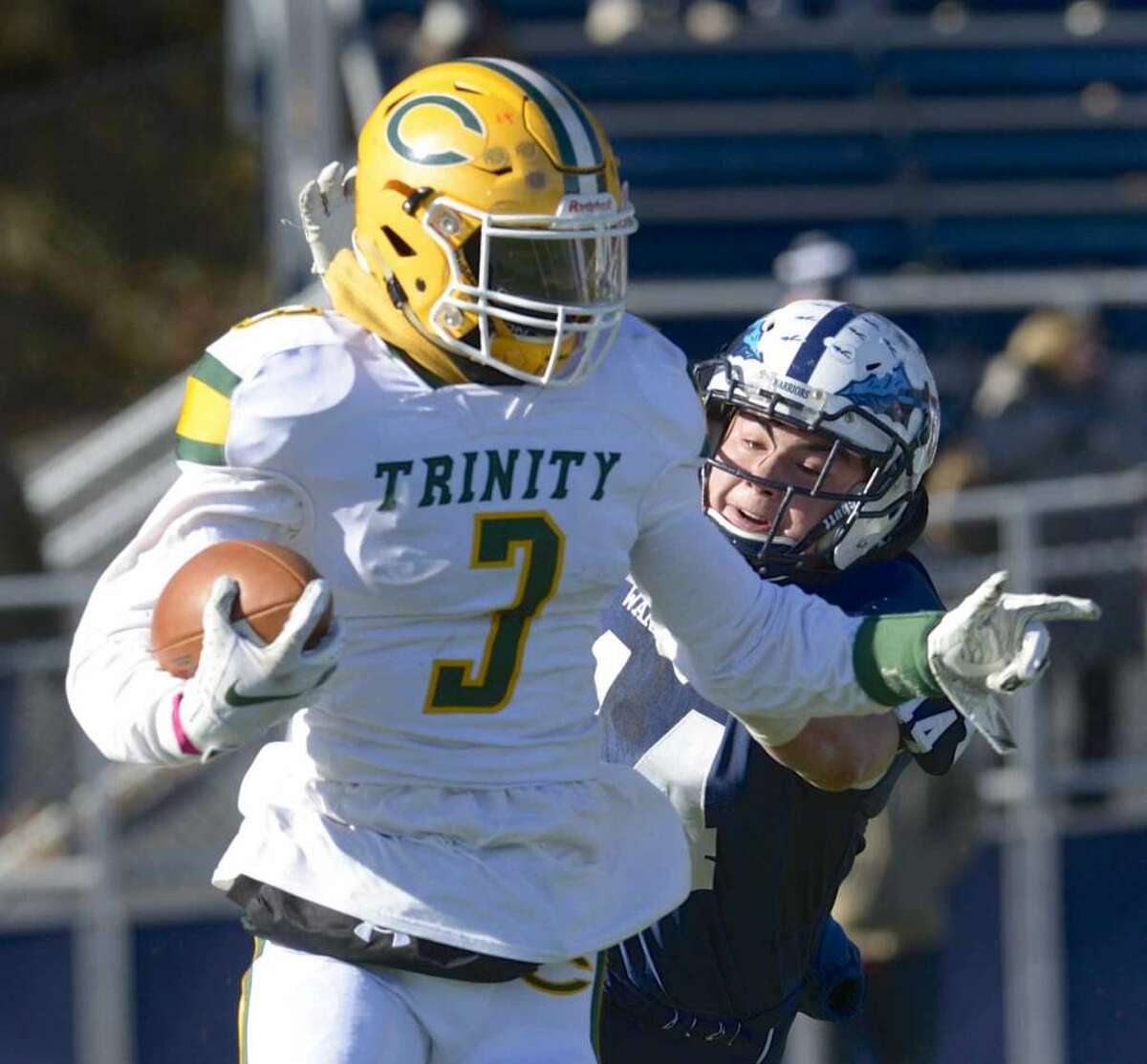 Trinity Catholic’s Tahjee Morgan breaks a tackle against Wilton last season. (File photo / Hearst Connecticut Media)